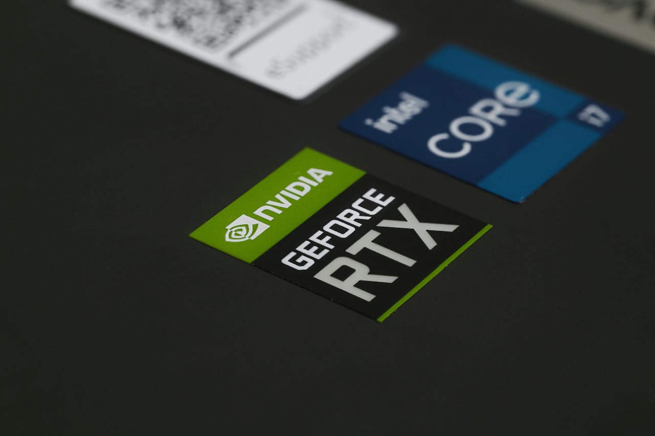 Close-up of NVIDIA GeForce RTX and Intel Core i7 stickers on a laptop surface, showcasing modern technology.